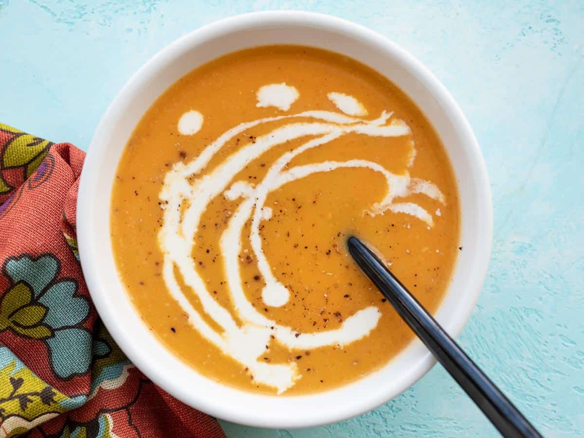 One bowl of creamy sweet potato soup garnished with cream and pepper