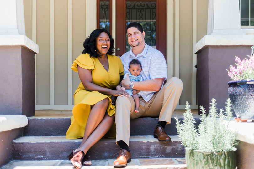 family of three sitting on steps outside