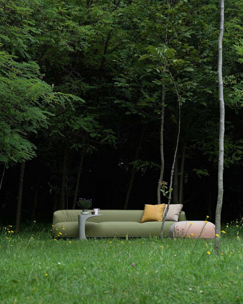 sofa with pillows outdoors in front of trees