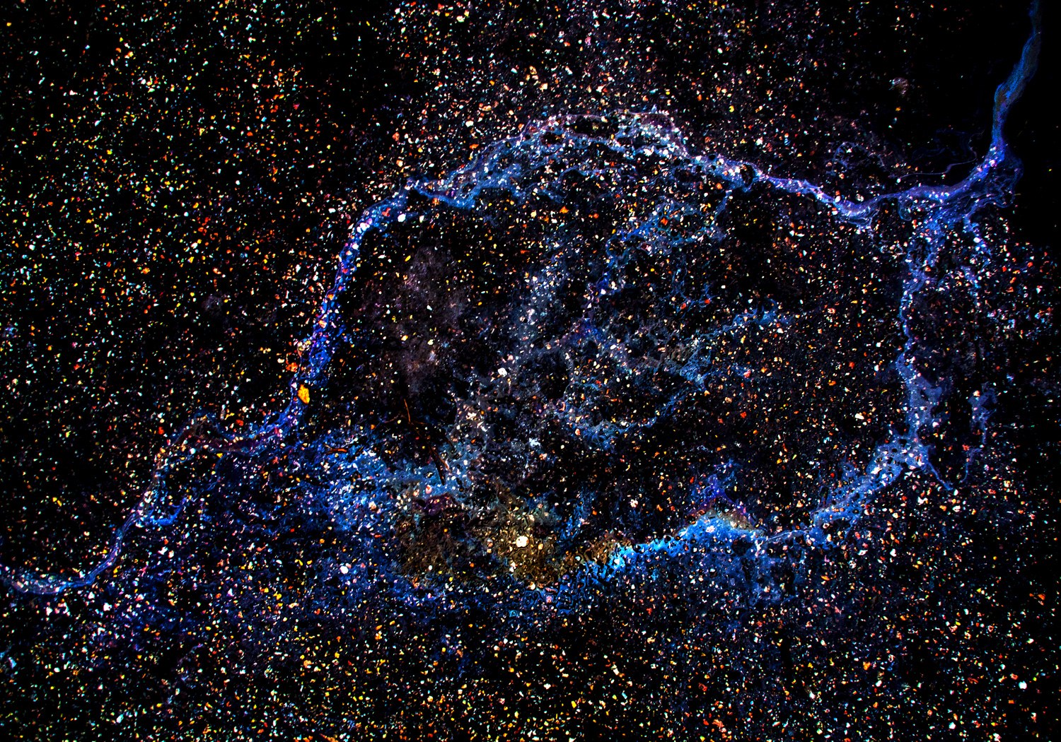 A photograph of Juha Tanhua's oil paintings which look like cosmic scenes from a telescope