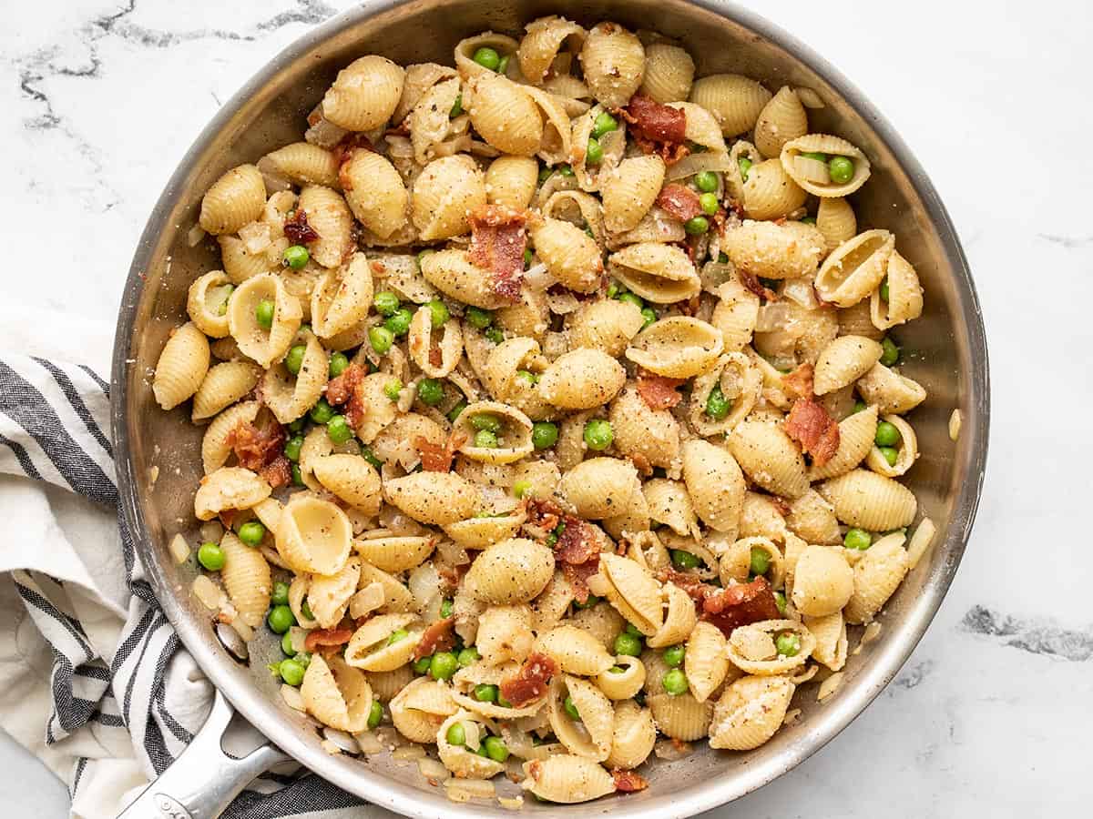 Pasta with bacon and peas in the skillet.