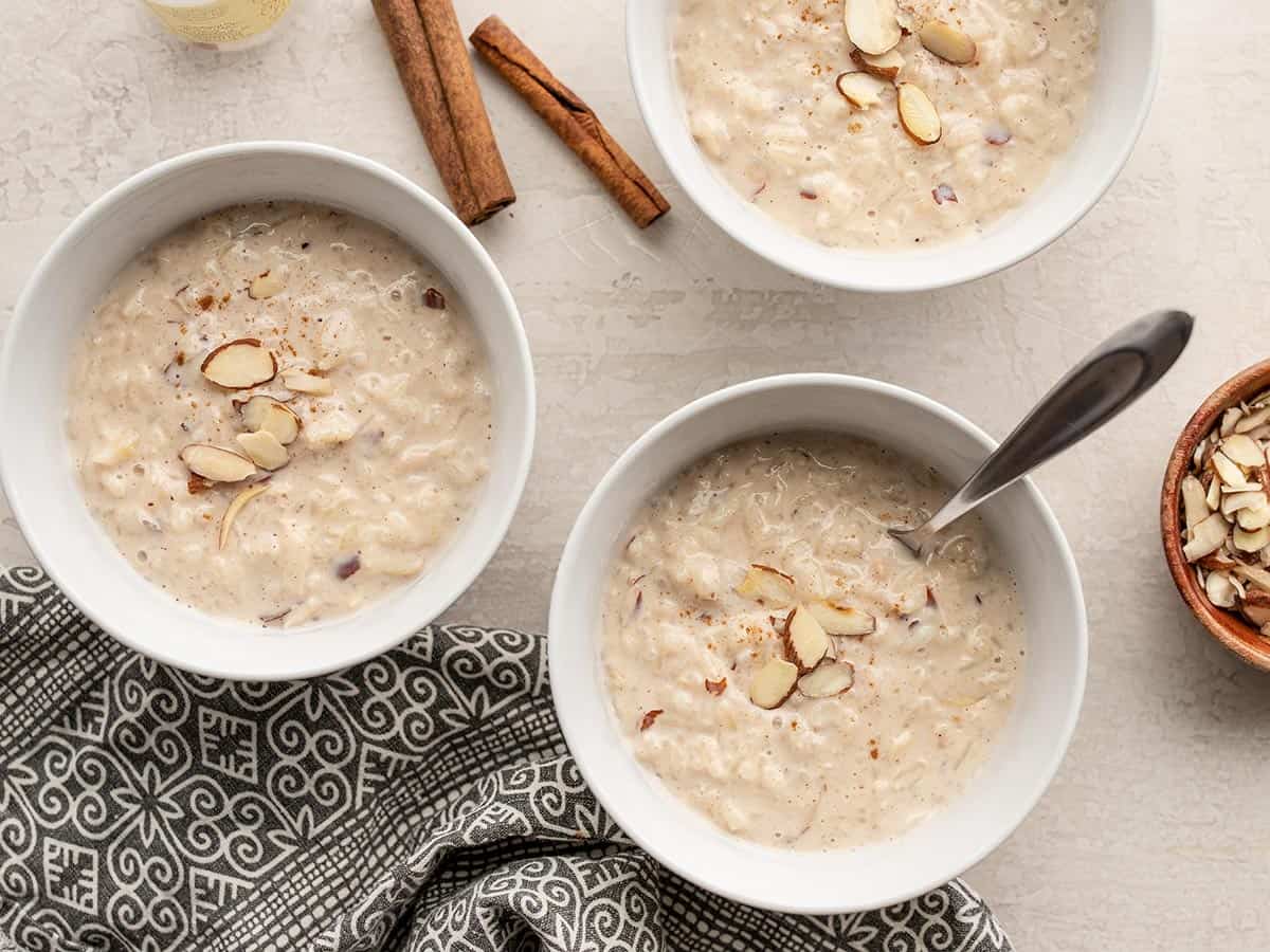 Three bowls of rice pudding topped with sliced almonds