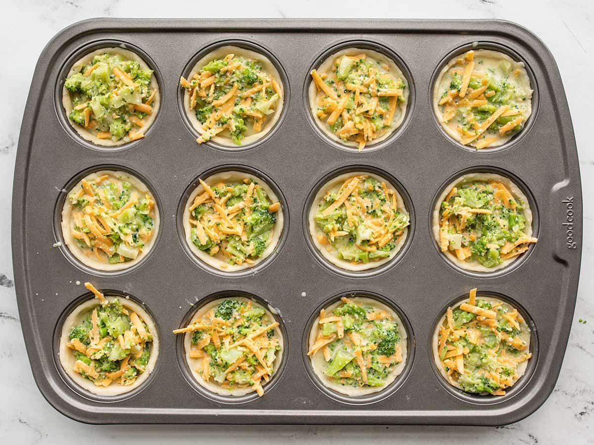 broccoli cheddar quiches in the muffin tin ready to bake.