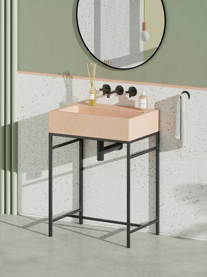 light pink square pedestal sink with black legs and wall fixtures