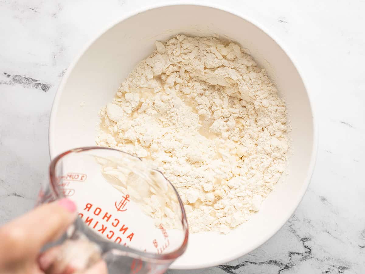 Overhead shot of water being added to flour and butter mixture.