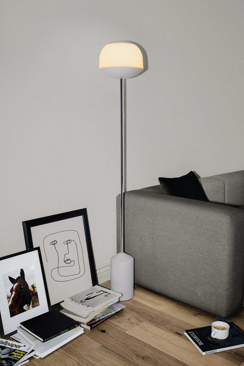 minimal floor lamp next to sofa and art